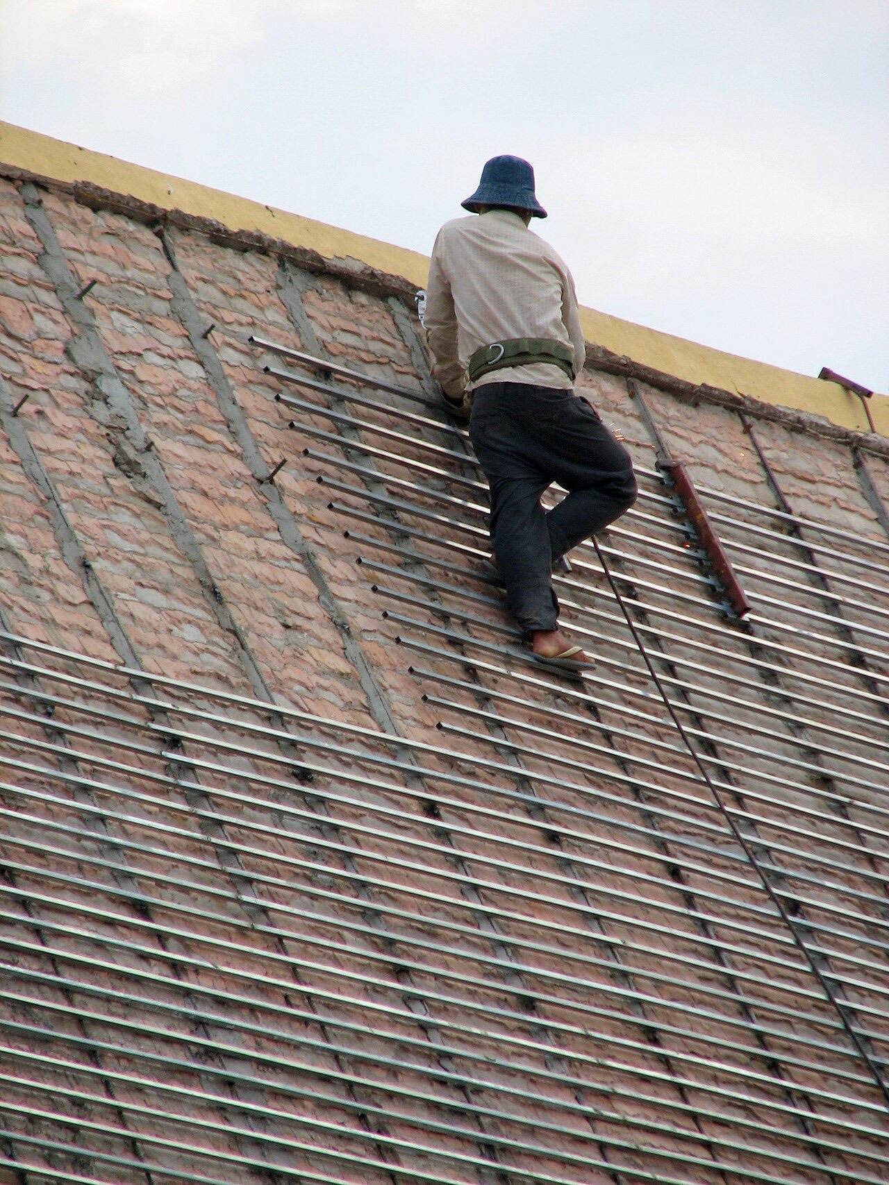 Worker fixing the roof of building in Royal Palace Cambodia
